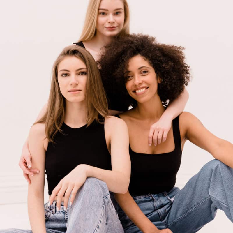 Three women with different hair types — straight, wavy, and curly — representing diversity in hair texture.”